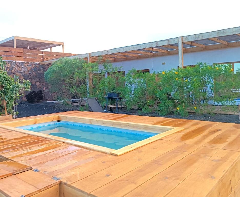 a swimming pool on top of a wooden deck at Aloha Studio in La Oliva