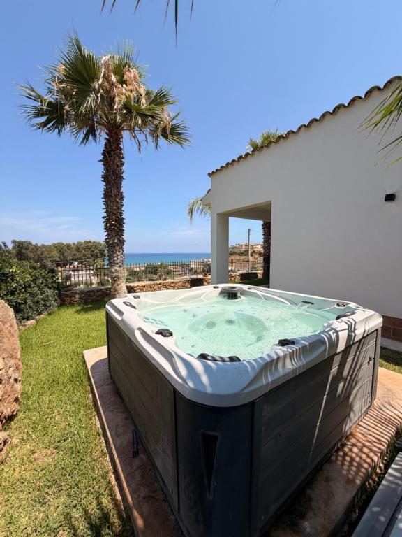 a hot tub in a yard with a palm tree at Villa Marina Luxury in Balestrate