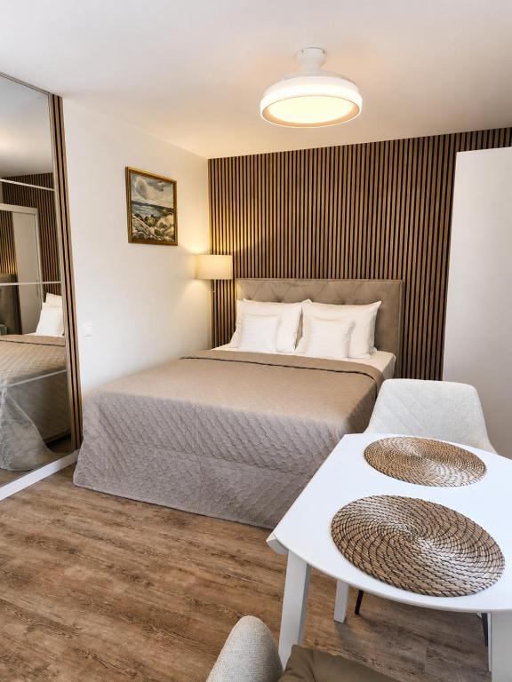 a hotel room with a bed and a table at Kopų gatvės studija Nidoje in Nida