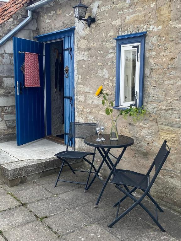 a table and chairs in front of a blue door at Old town Stylish Stonehouse Kauba 6a in Kuressaare
