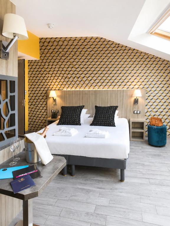 a bedroom with a large bed in a room at Unique Hôtel Résidence & Spa in Saint-Raphaël