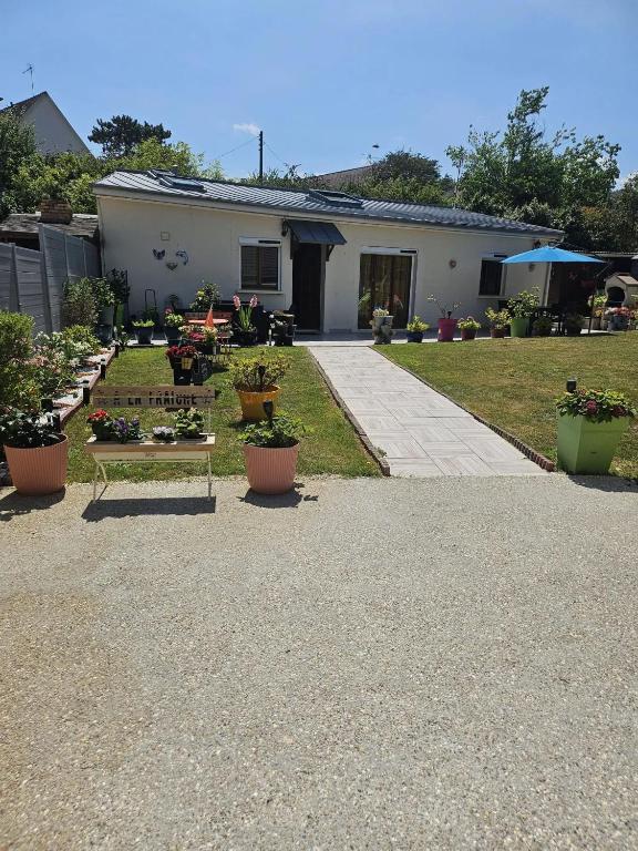 a house with a bench and plants in the yard at Maison confortable à Ver-sur-Mer avec jardin privé in Ver-sur-Mer