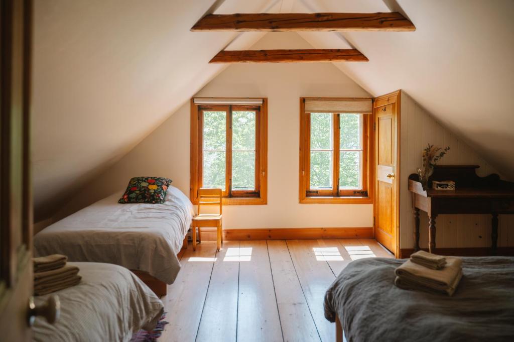 a attic room with two beds and a piano at Triangle de l'île Chambre le Grenier in Saint-Laurent-de-l'ile d'Orleans