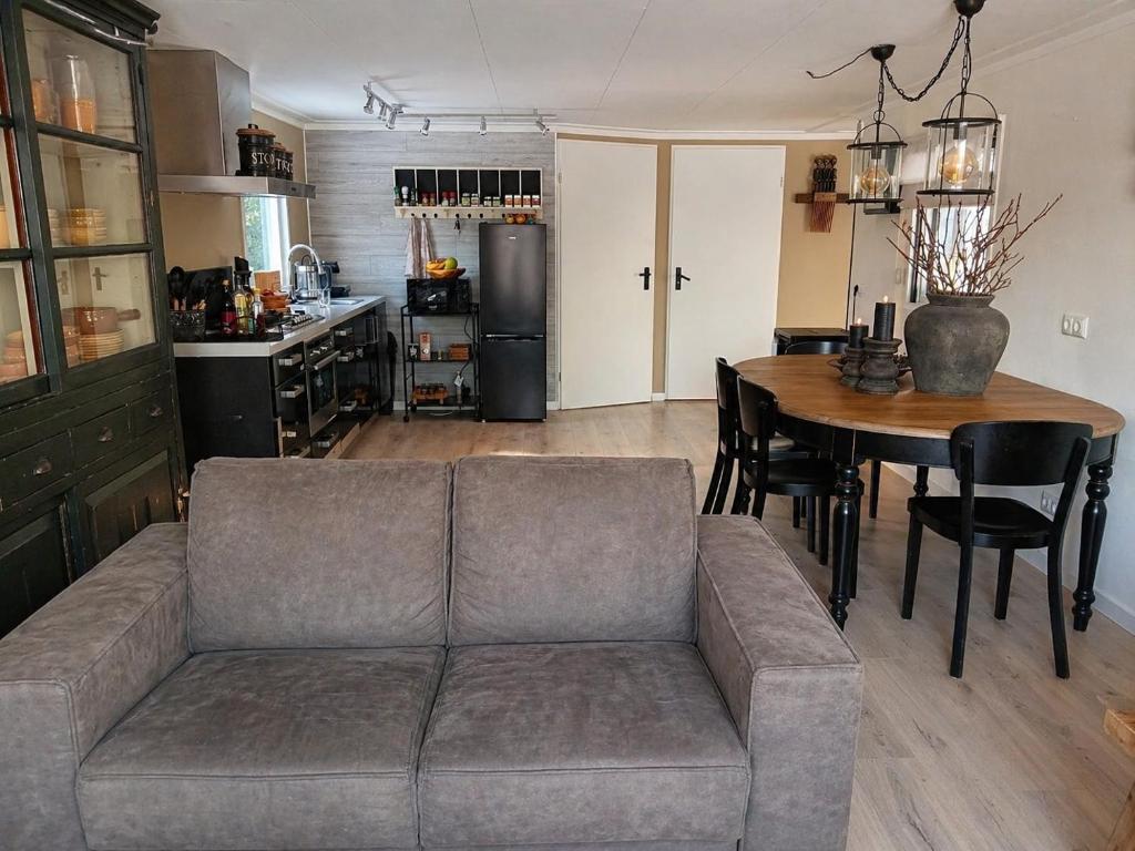 a living room with a couch and a table at Vechtdalchalet, De Wilg in Rheezerveen
