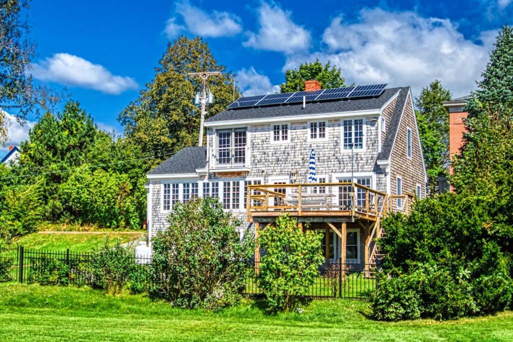 una casa con pannelli solari sul tetto di Elegant home right in town with gorgeous water view, deck & interior a Wiscasset