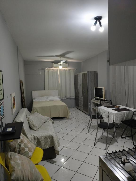 a bedroom with a bed and a table and a tv at Studio Centro Floripa 02 in Florianópolis