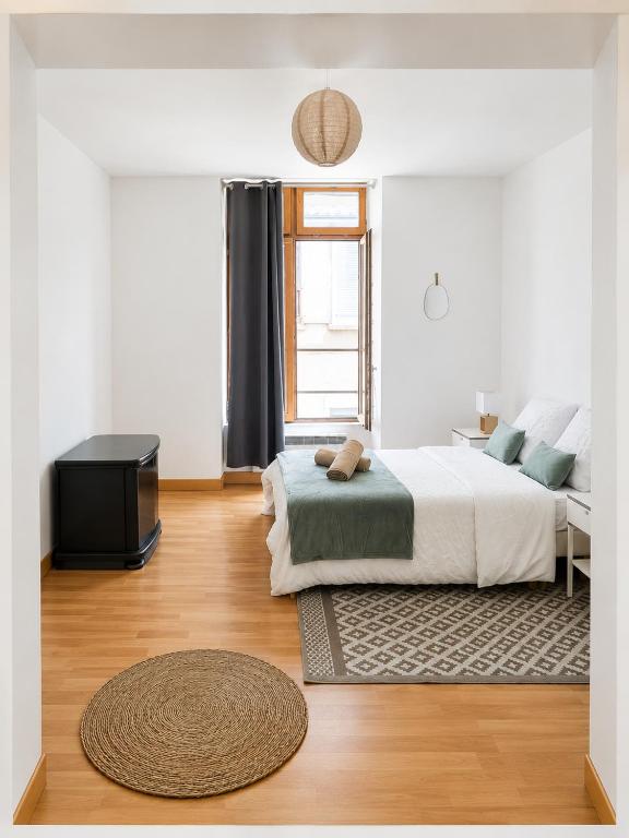 a bedroom with a bed and a window and a rug at L'Escale de Bonny in Bonny-sur-Loire