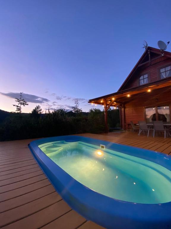 a swimming pool on a deck with a house at Dom Wakacyjny Letnisko in Ujsoły