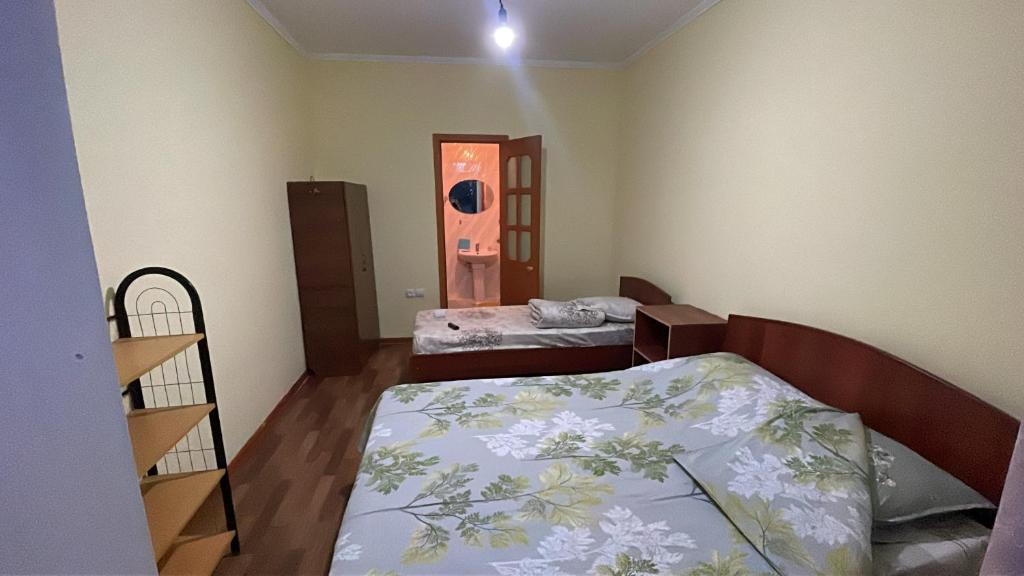 a room with two beds and a mirror in it at Гостевой дом Арай in Bosteri