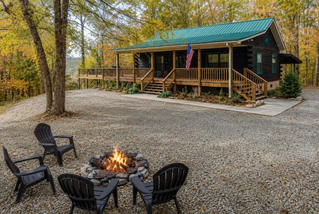 a fire pit in front of a log cabin at Happy Top Hideaway in Bryson City
