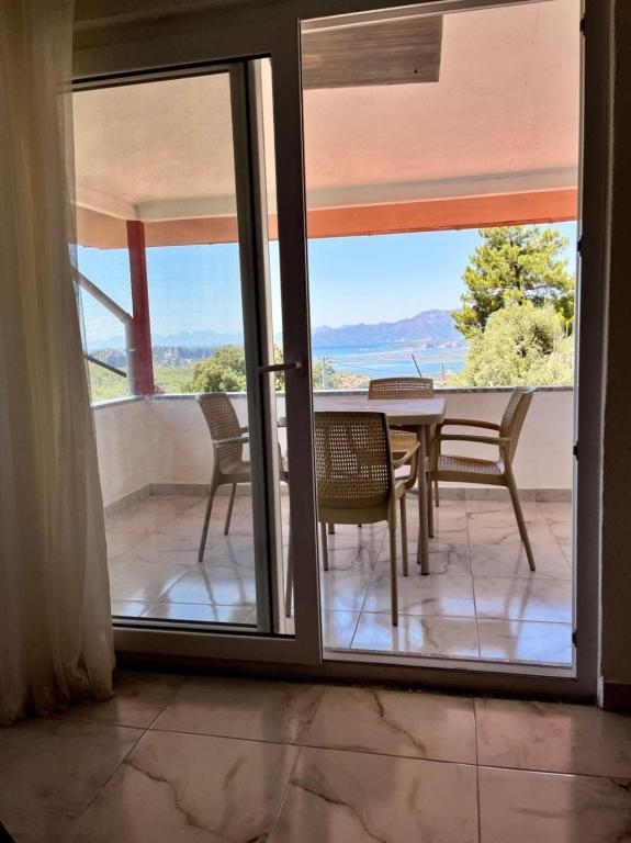 a glass door leading to a patio with a table and chairs at kozalak evleri in Gökbel