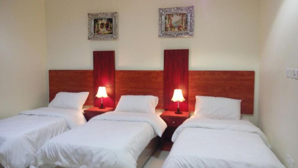 Tempat tidur dalam kamar di Nice Suites & Hotels