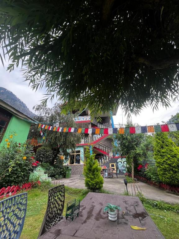 a patio with a table and chairs in a yard at Maya Homestay & Cafe in Kasol