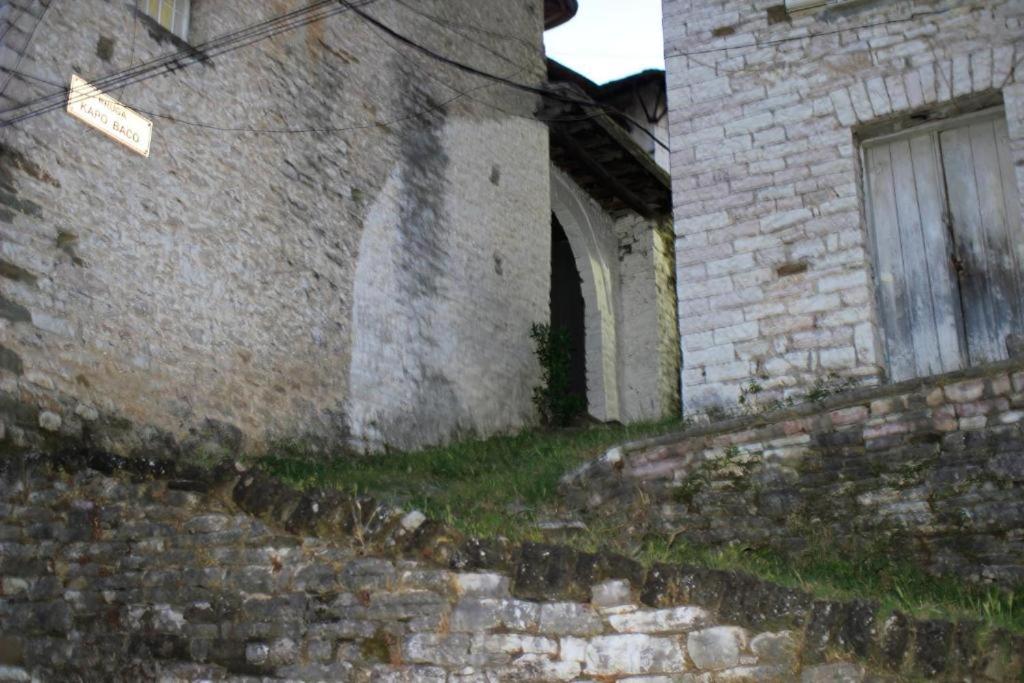 an old brick building with a door and a window at AmedaPm in Gjirokastër