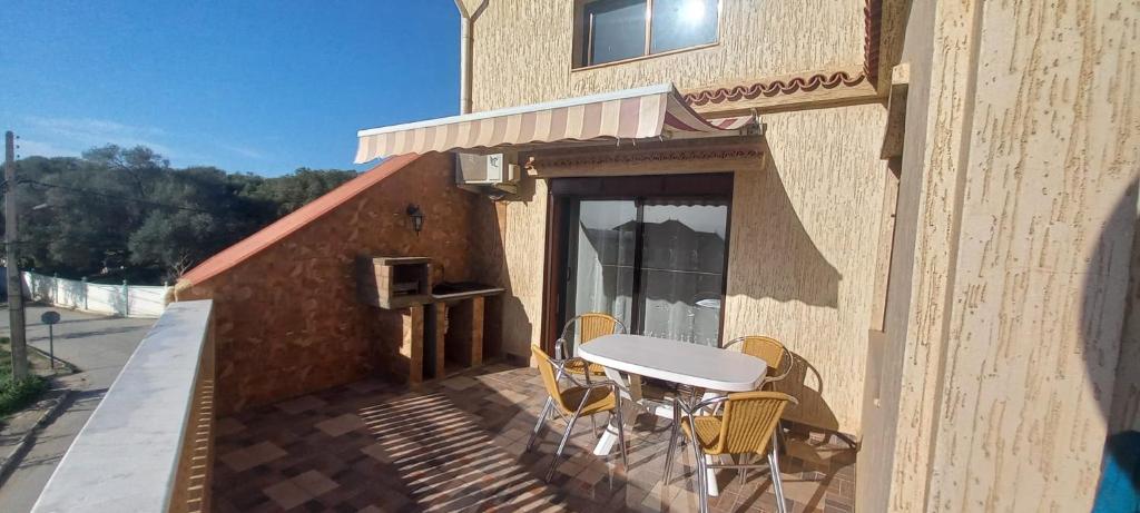 a patio with a table and chairs on a balcony at Duplex pres de la mer a Alger in Rouiba