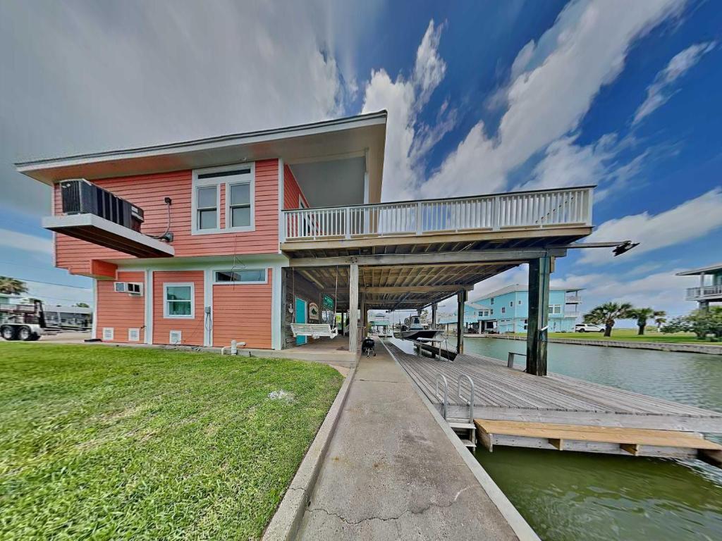 a house with a deck on a dock at West Bay Getaway in Galveston