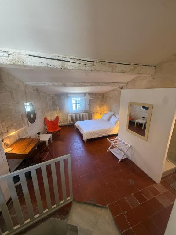a large room with a bed and a staircase at Les chambres de Pierre in Arles