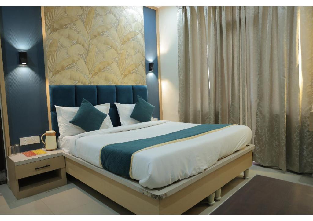 a bedroom with a large bed with a blue headboard at Shree Sanmat Guest House in Gwalior