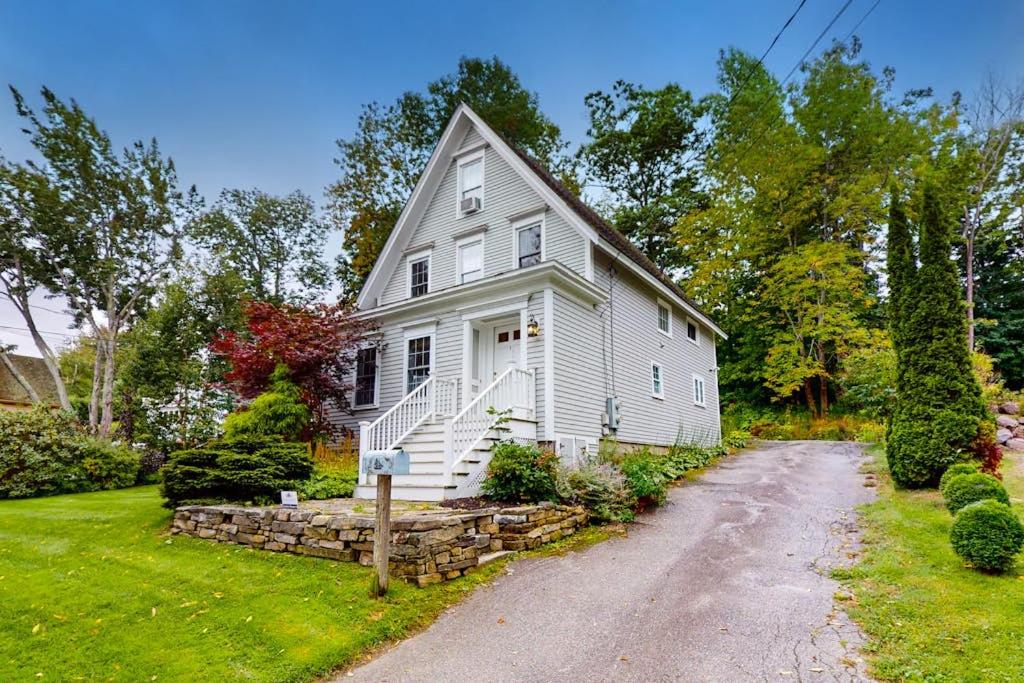 a white house with a driveway in front of it at Gorgeous, walkable home with water view, deck & washer/dryer - snowbird-friendly in Camden