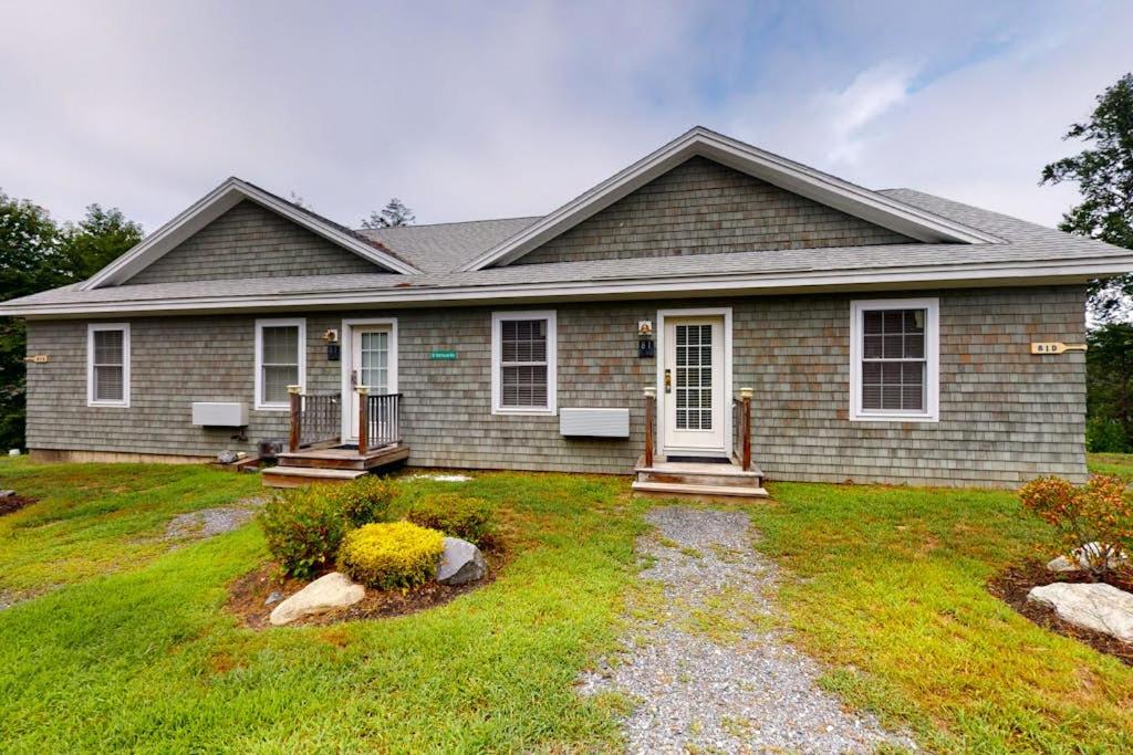 a home with a house with a grass yard at Stylish Condo at Sheepscot Harbor Resort w/Free WiFi, River Views, & Balcony in Edgecomb