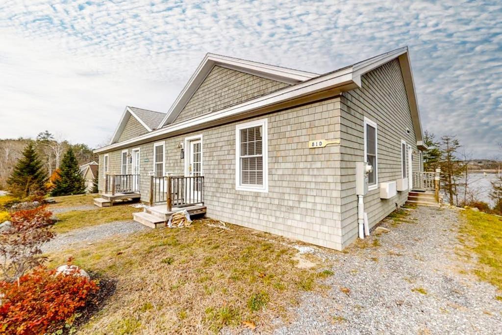 a small house with a porch on a yard at Water-view condo at Sheepscot Harbour Resort with deck, full kitchen, and WiFi in Edgecomb