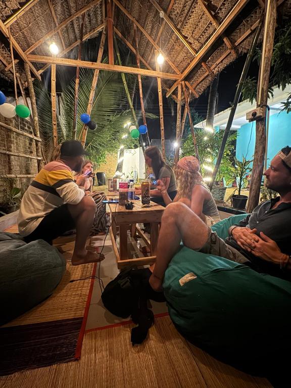 a group of people sitting around a table at Moonlight surf hostel in Arugam Bay