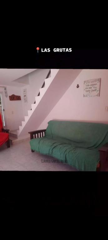 a bedroom with a green bed and a staircase at Arena & mar in Las Grutas