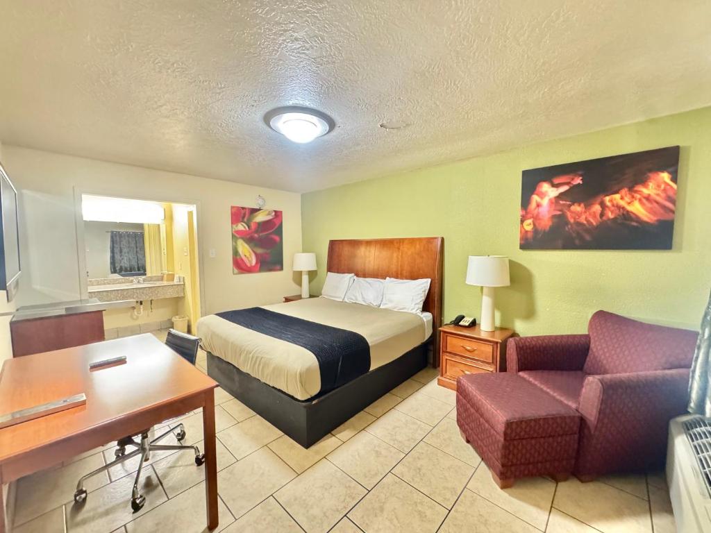 a hotel room with a bed and a couch at Texas Inn Beaumont in Beaumont