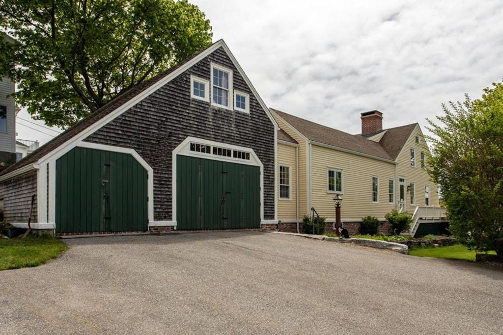 a large house with green garage doors on a driveway at All-suite Boothbay Harbor home with deck, ocean views, and fireplaces in Boothbay Harbor