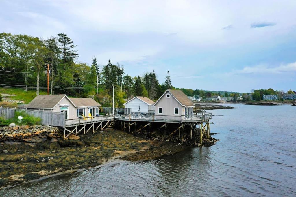 a dock with houses on it next to the water at Oceanfront Cottage & Studio on Mill Cove w/ Water Views, Deck - Walk Downtown in Boothbay Harbor