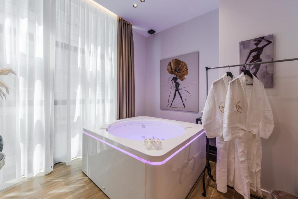 a white bathroom with a tub and a window at Via Mare Jacuzzi Suites by PS in Durrës