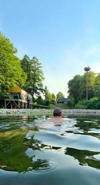 a person swimming in a body of water at Siedlisko Sobibór in Sobibór
