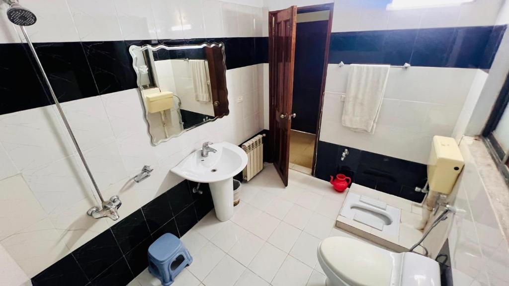 a bathroom with a toilet and a sink at The Al-Maaz Guest House in Murree