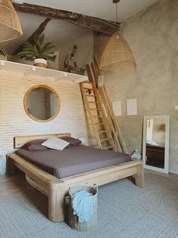 a bedroom with a bed and a staircase and a mirror at Escapade bohème in Bergerac