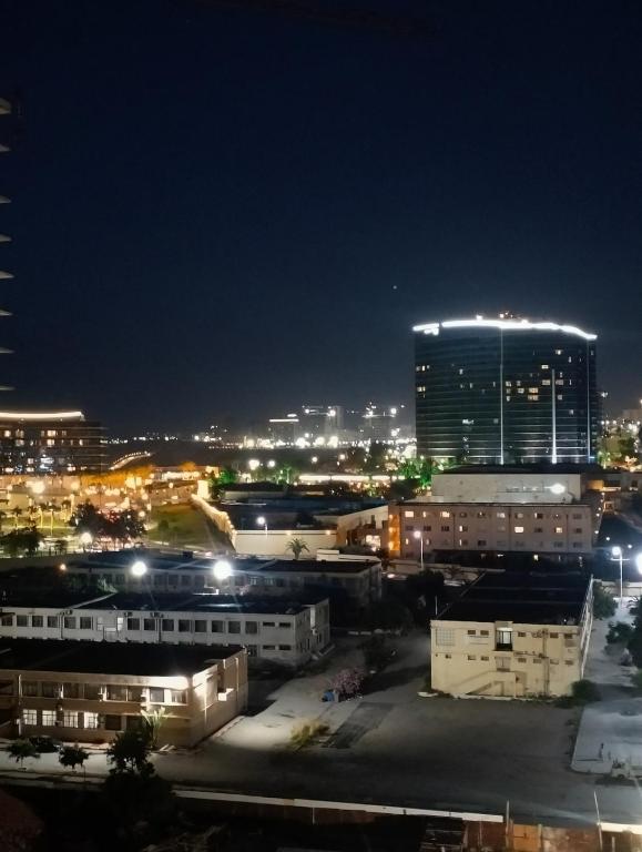 a city lit up at night with a tall building at Dani's Sea Breeze in Oran