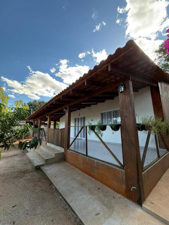 a building with a porch and stairs next to the water at Casa Pé da Serra in Estivado