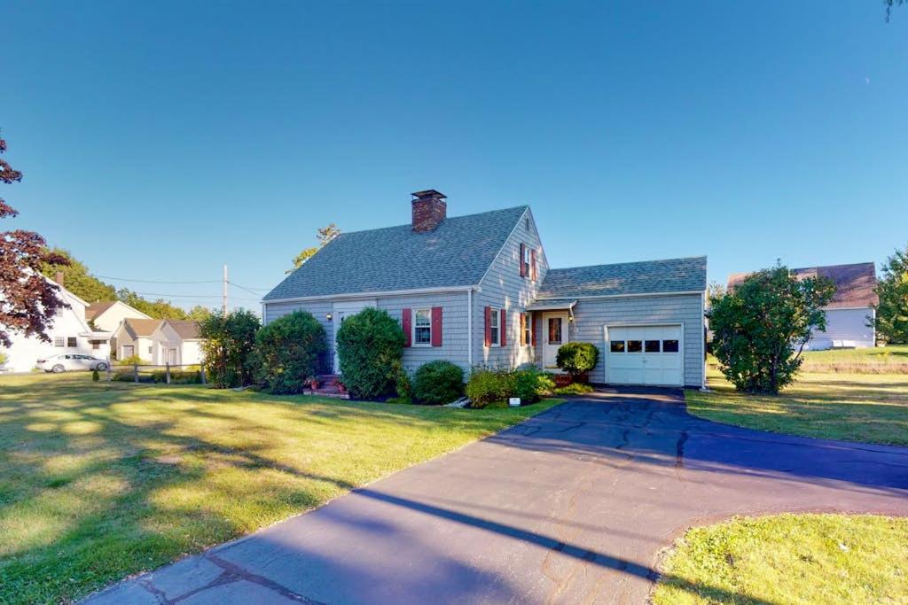 a white house with a driveway in a yard at Comfortable home near the beach - dog-friendly - full kitchen & washer/dryer in Rockland