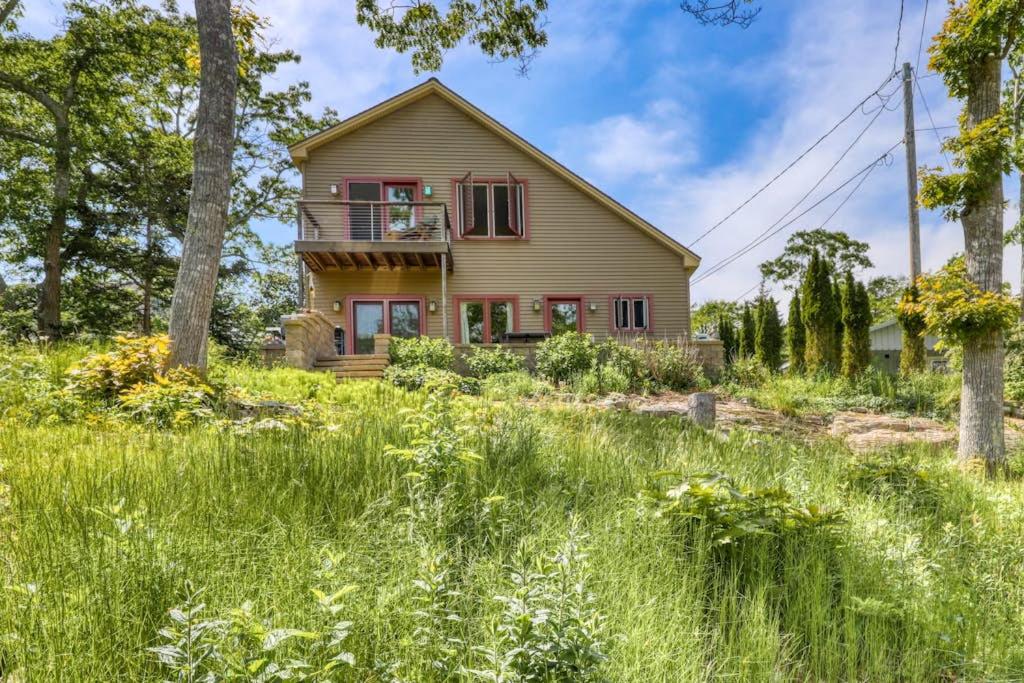 a house in the middle of a field of tall grass at Dog-friendly home with high-speed WiFi, washer/dryer, & private dock in Cundys Harbor