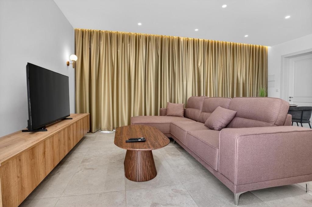 a living room with a couch and a tv at Stylish Penthouse with private Pool andJacuzzi in Naxxar