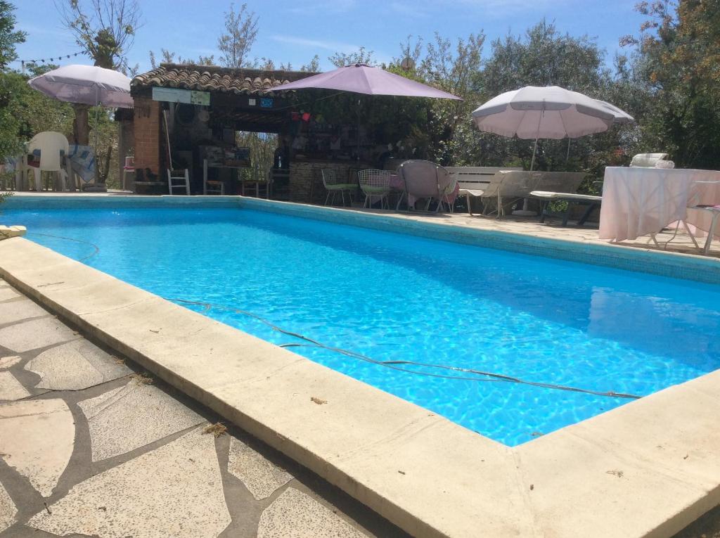 a swimming pool with blue water in front of a house at Lou ribas in Puyloubier