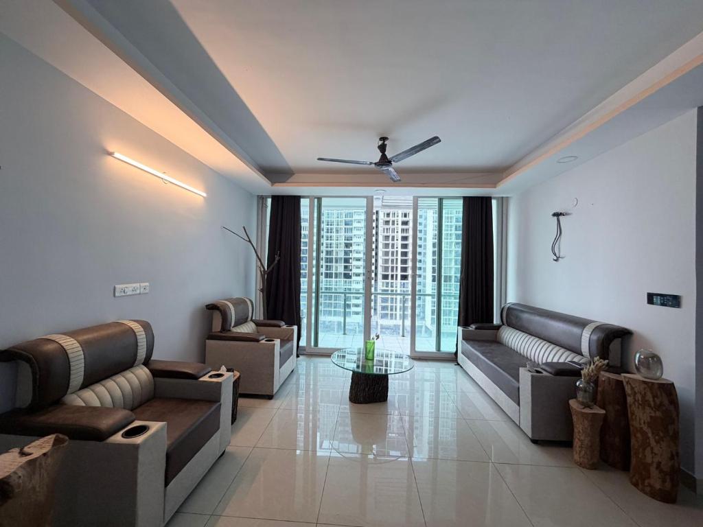 a living room with couches and a large window at The Lake view Timber House in Hyderabad