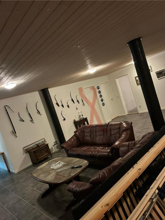 a living room with a leather couch and a table at Eventyrborgen in Eskilstrup