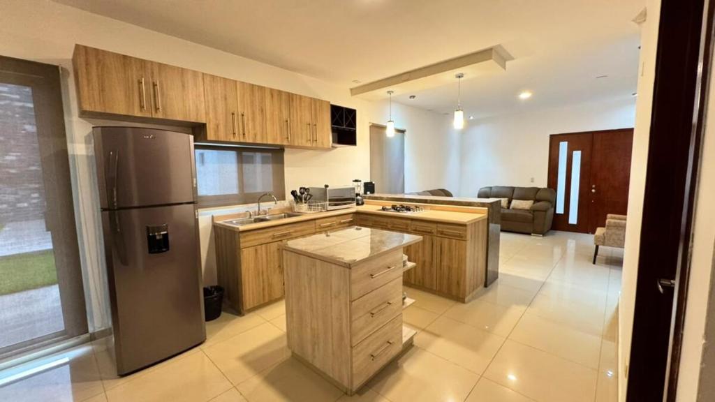a kitchen with wooden cabinets and a stainless steel refrigerator at Departamento moderno en Durango in Durango