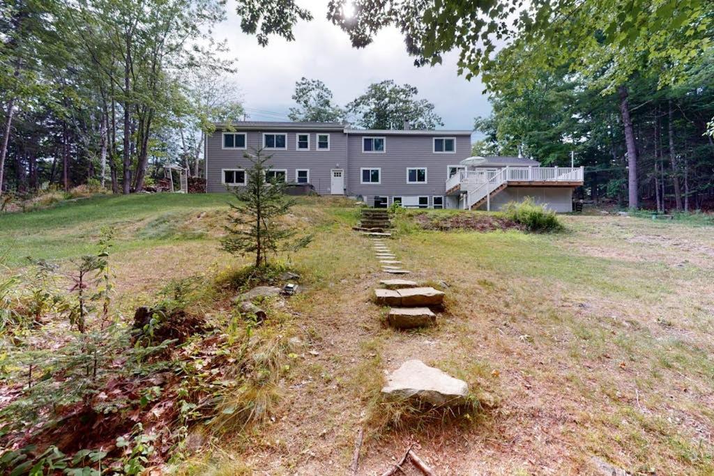 a large house on a hill with steps in front of it at Waterfront home with deck, patio, grill, firepit, Ping-Pong, & WiFi in Somesville