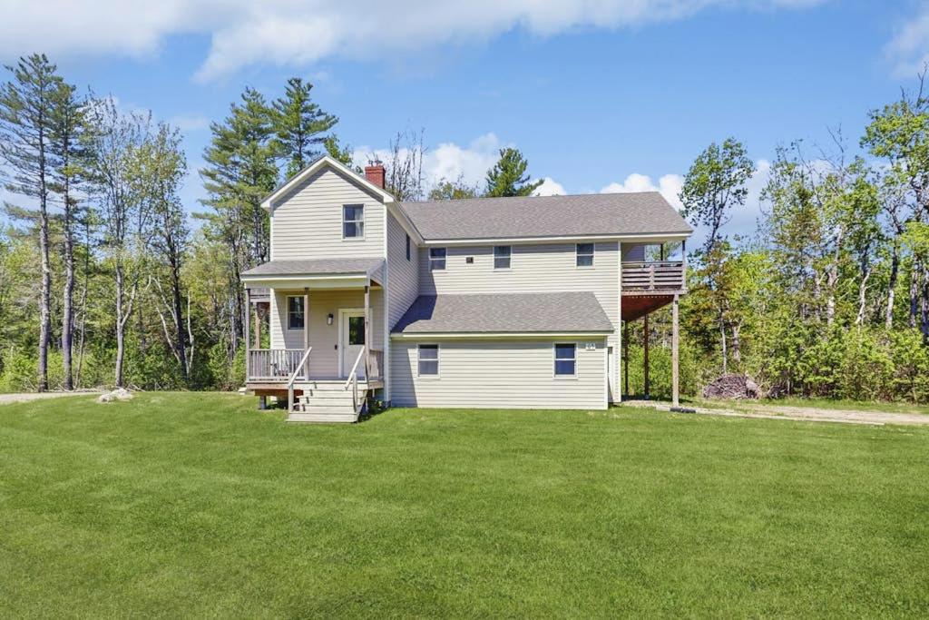 a house with a large yard with green grass at Modern farmhouse with deck, firepit, & balcony in Northport