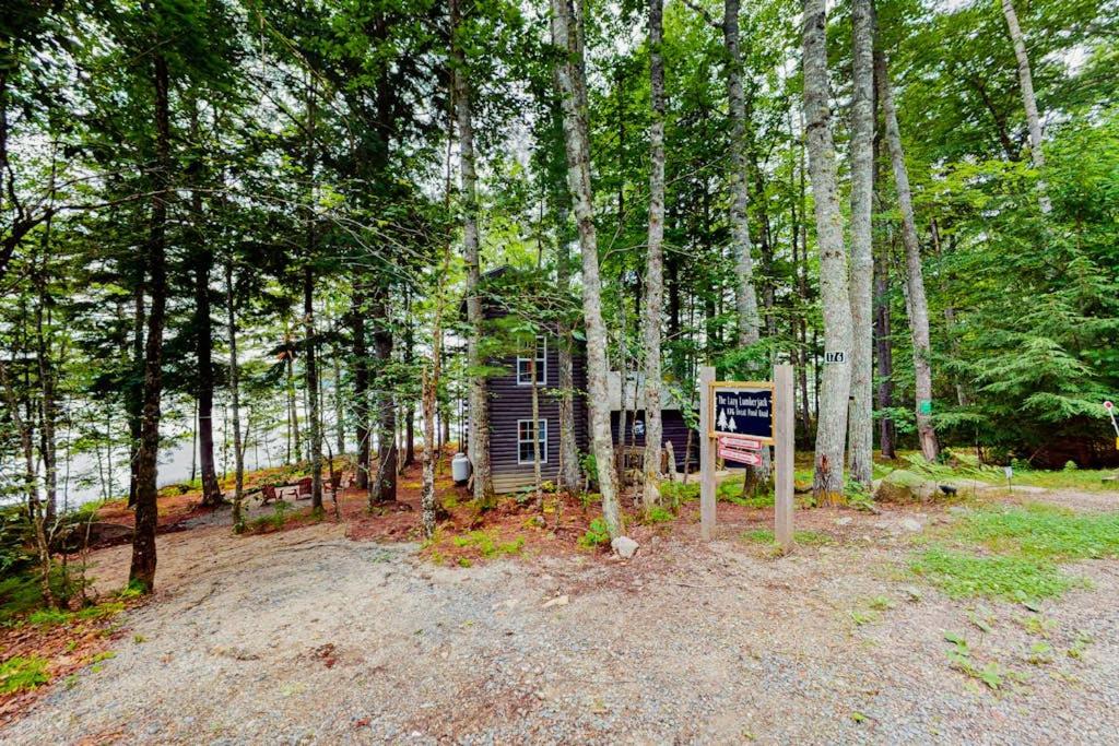 a small cabin in the middle of a forest at The Cottage - Peaceful 32-Acre Lakefront Getaway - Canoe, Firepit & Big Deck in Franklin