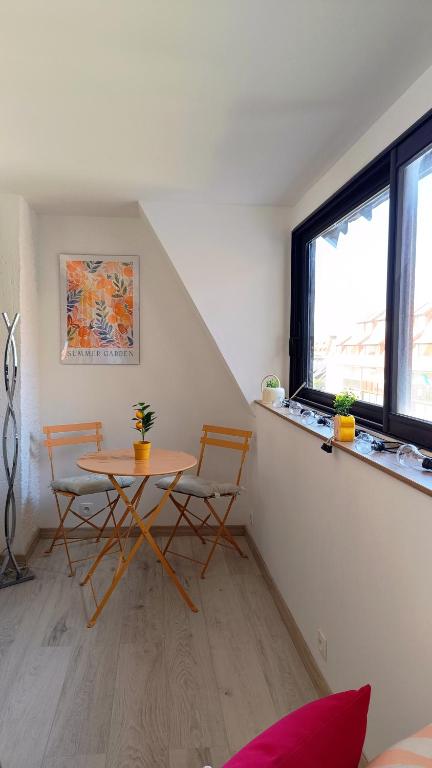 a room with a table and two chairs and a window at Appartement L'esprit marin in Villers-sur-Mer