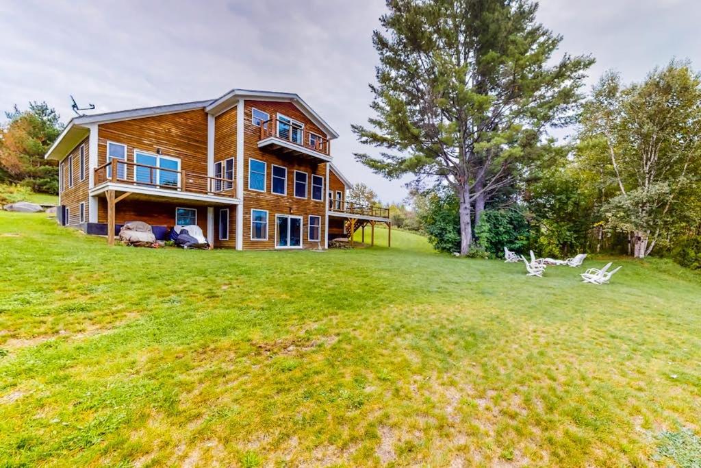a large house on a field with a large yard at Lakefront home with outdoor firepit & private dock - near downtown in Greenville