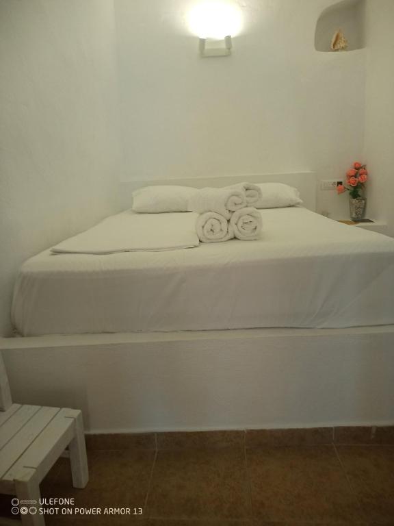 a white bed with two towels on top of it at ''RENATA'' Studio in Kithnos