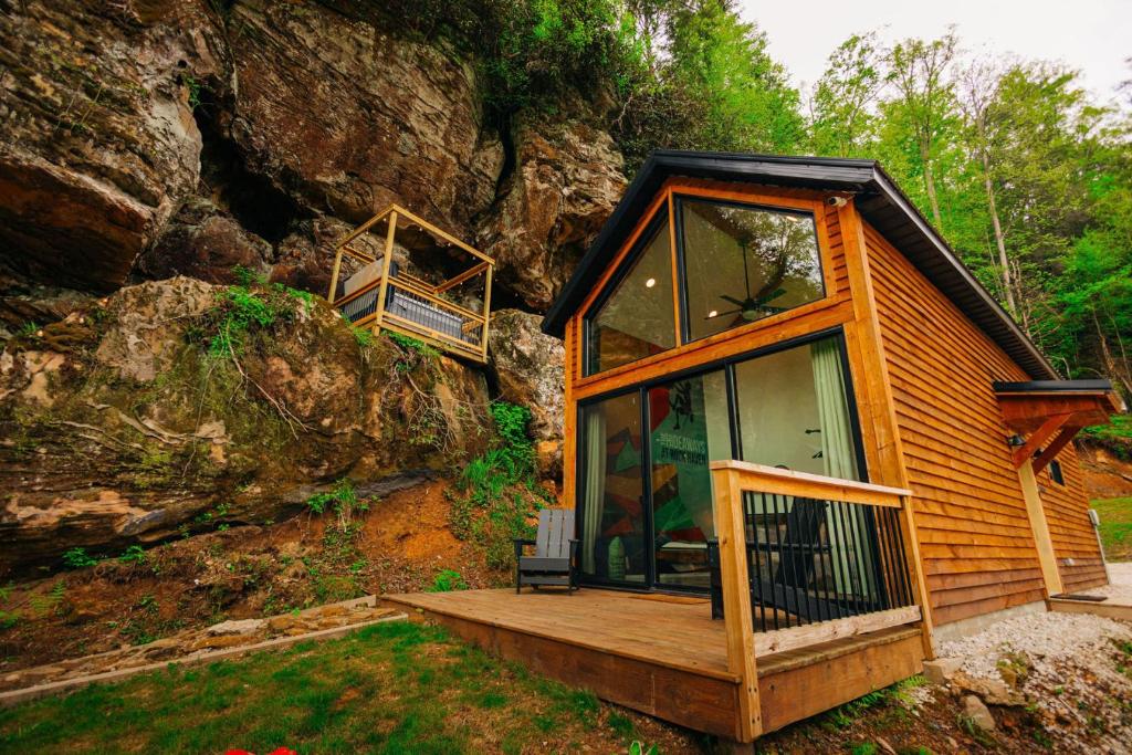 a cabin with a large glass door on a mountain at Cliff Hot Tub with Deck Fire Pit Mural and Pet Friendly in Rogers